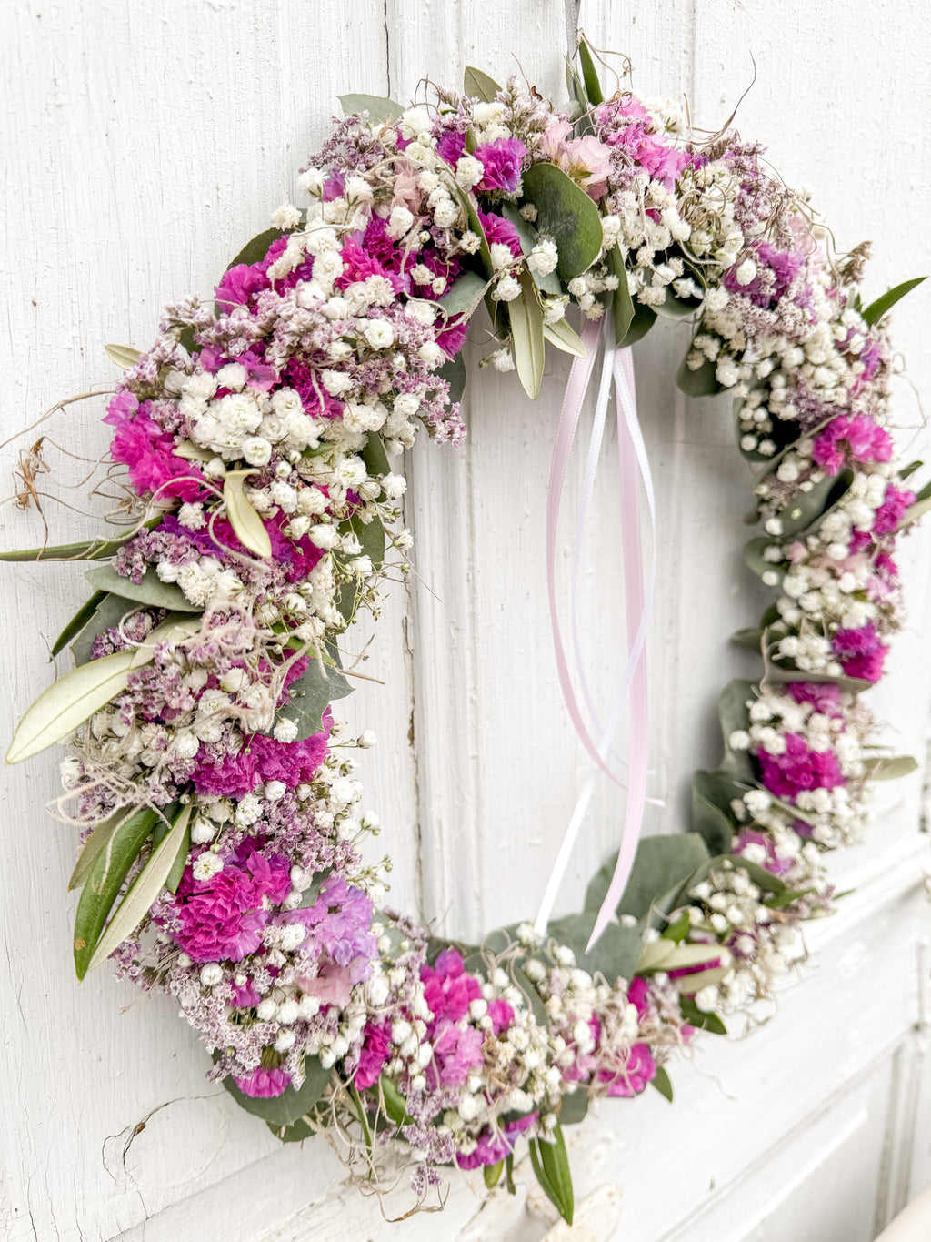 »1/1 FlowerLoop Rosa« vor weißer Wand – Eukalyptus, Schleierkraut, rosa Strandflieder und Tillandsia-Moos