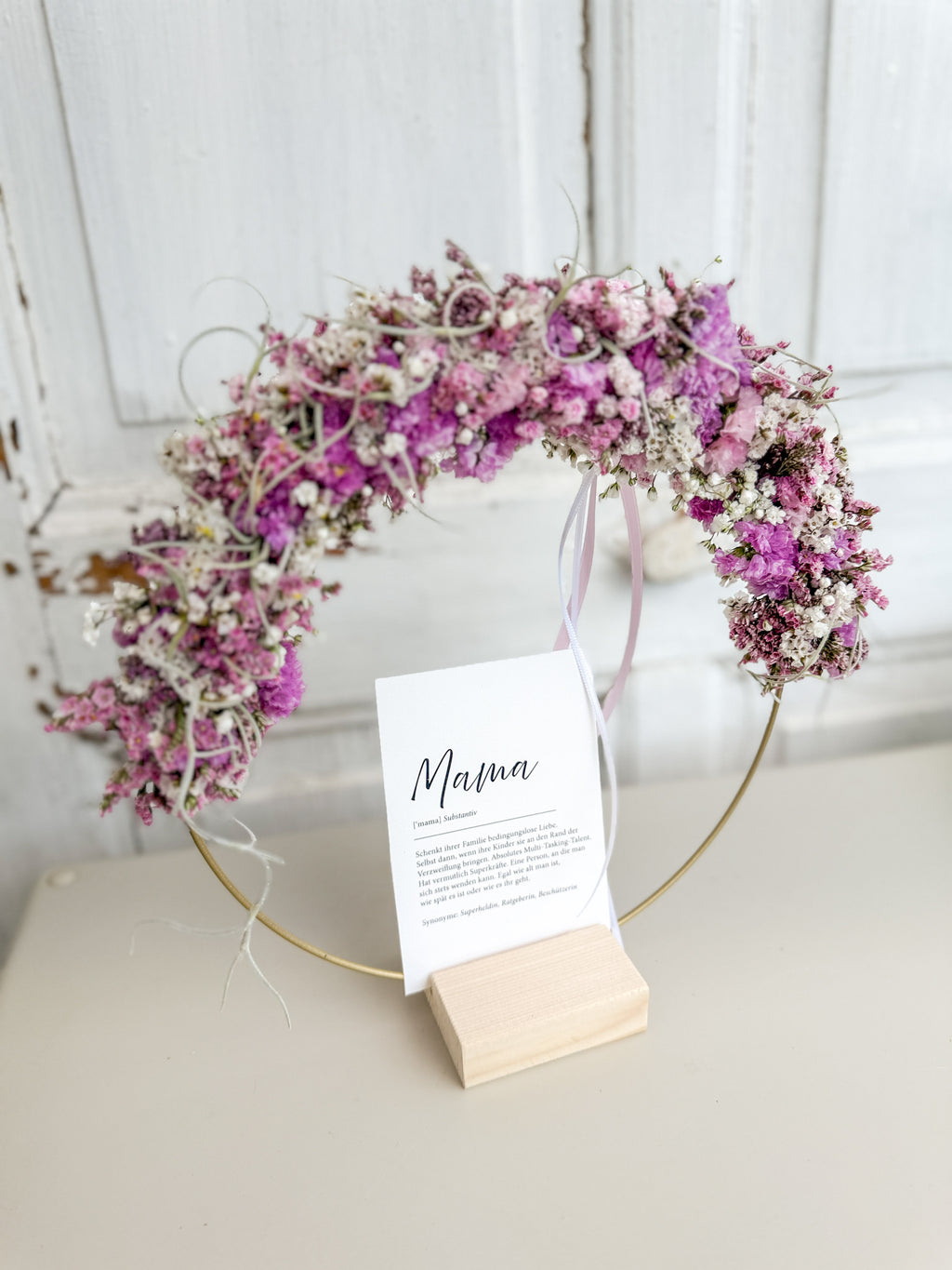 1/2 Flowerloop auf Holzständer mit frischen Blüten in rosa und Postkarte „Mama“ als Muttertagsdeko