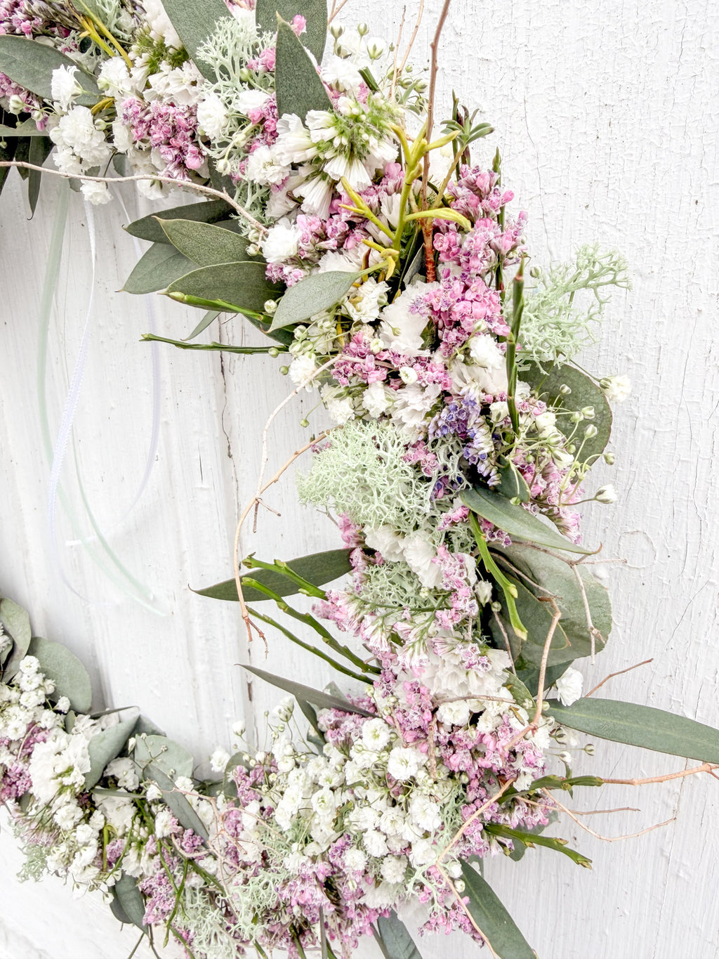 Detailaufnahme Flowerloop »Pink Spring«: rosa Strandflieder, weißes Schleierkraut, Islandmoos und Euphorbia spinosa auf Metallring