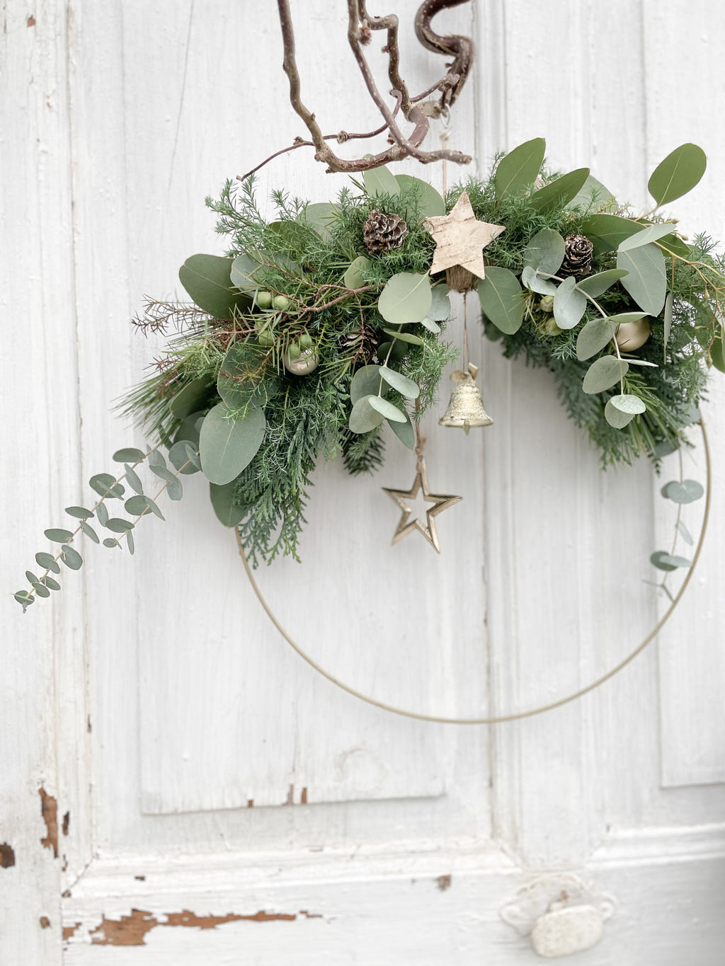 1/2 Winter-Loop ‚Evergreen Canopy‘ Hochformat, Metallring halbseitig dekoriert mit Eukalyptus- und Koniferengrün, Zweige überragen oberen Rand, Lerchenzapfen, Birkensterne, Dekokugeln