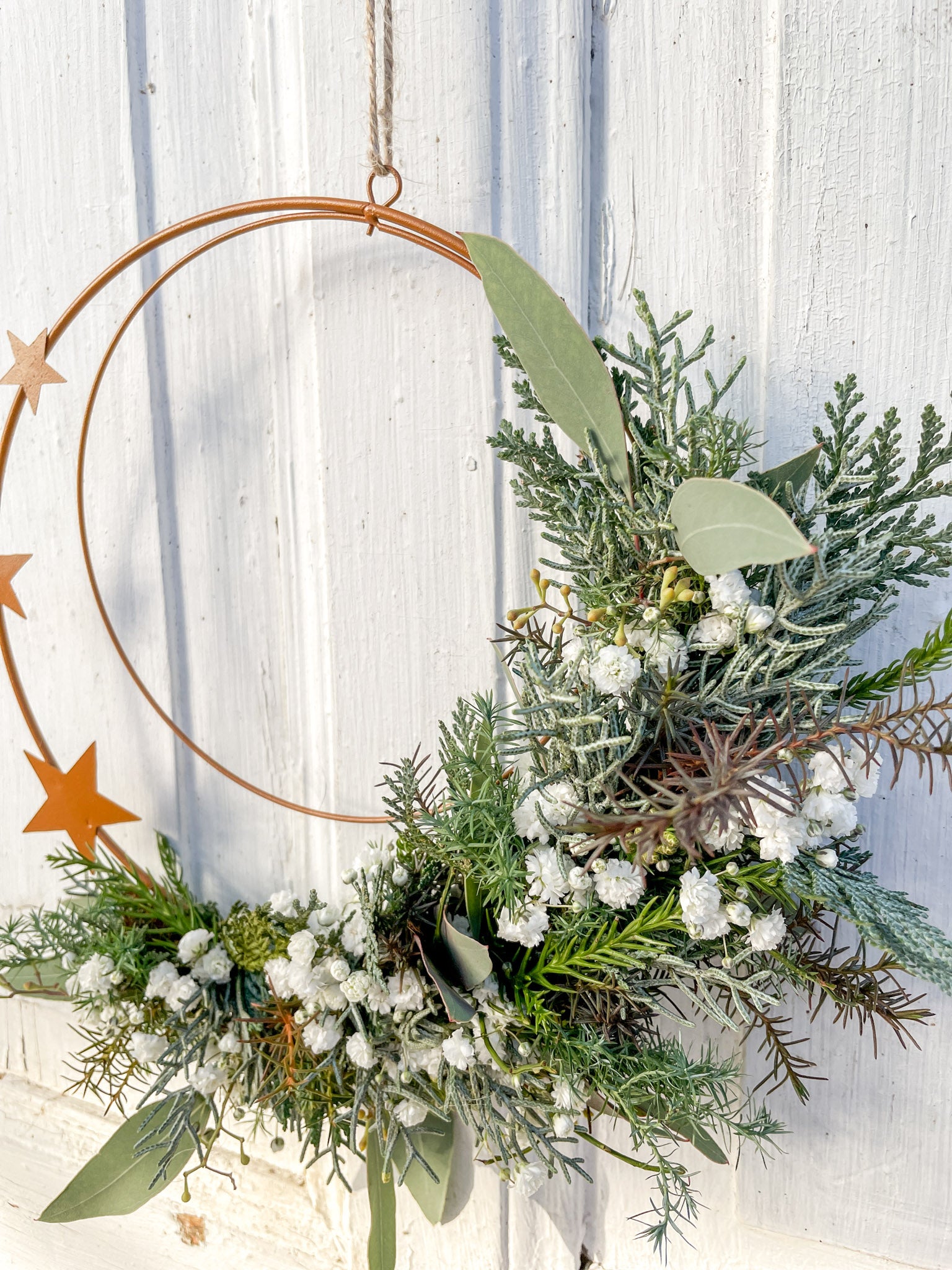 1/2 Winter-Loop ‚Rustic Stars‘ als Tür- oder Wanddekoration, Metallring in Rostoptik, halbseitig dekoriert mit winterlichem Koniferengrün, Schleierkraut und Sternen