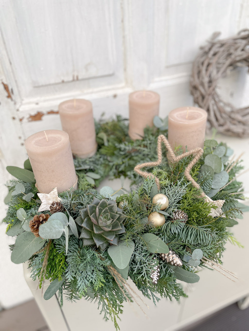 Adventskranz Naturschimmer - natürliche Materialien u.a. Tanne, Eukalyptus, diverses Nadelgrün, optional: Sukkulente. Stumpenkerzen in hellbraun ergänzt um Dekokugeln in champagner-gold und ein farblich abgestimmtes Dekohighlight (tbd). 