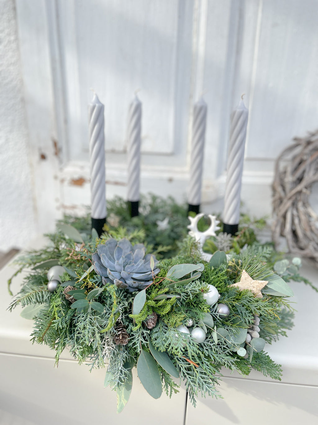 Skandi-Deko Adventskranz »Nebelhirsch-Twist« mit grauen Stabkerzen, Nadelgrün und Eukalyptus vor heller Holzwand