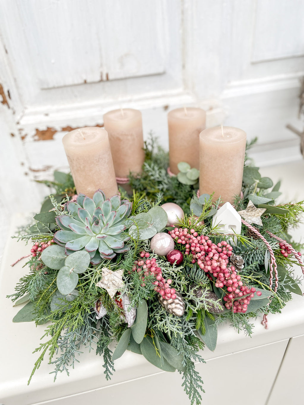 Handgebundener Adventskranz »Sandrose« mit cremebraunen Stumpenkerzen, rosa Kordel, Nadelgrün, Eukalyptus und weißem Häuschen