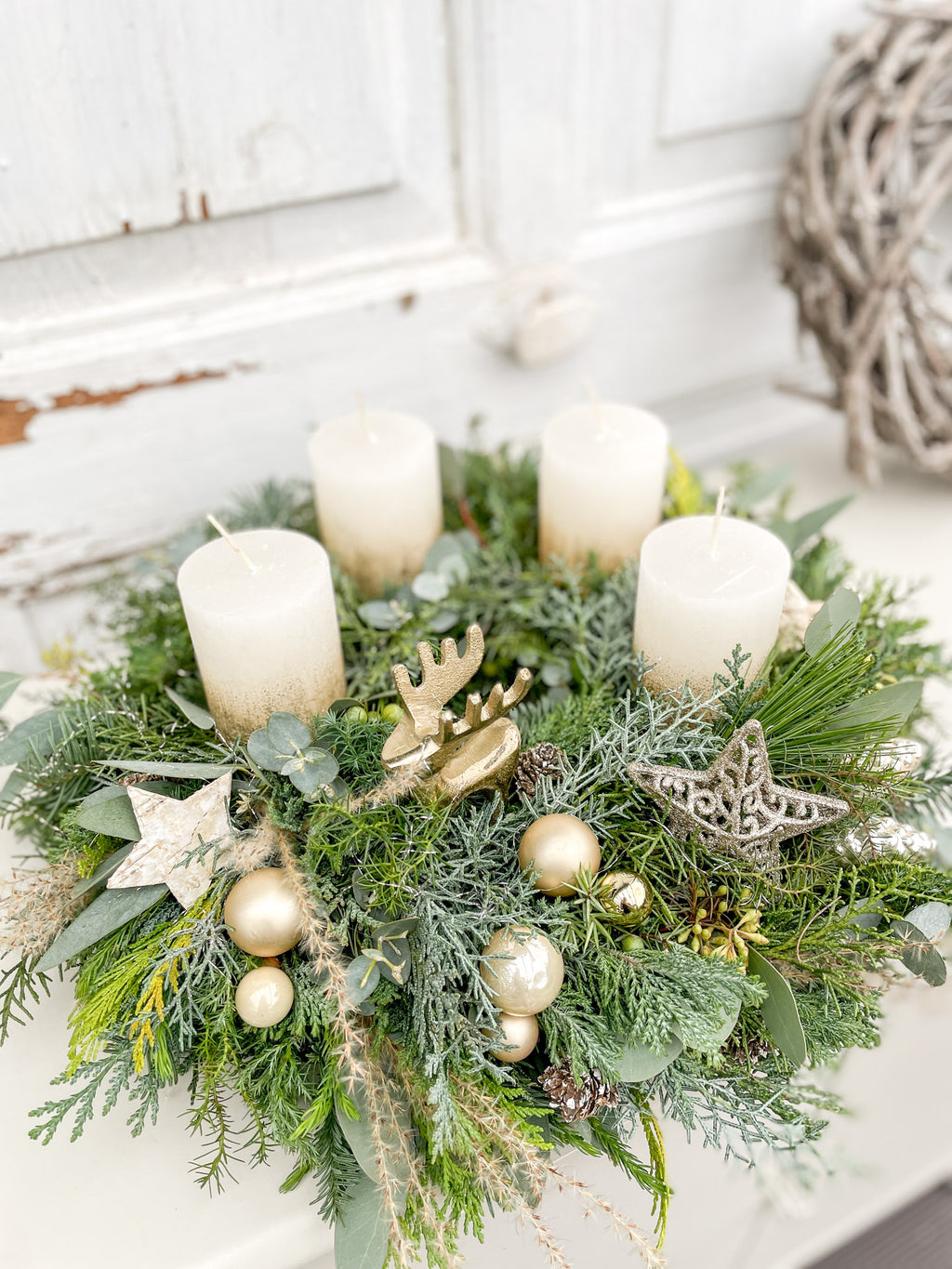 Adventskranz Wintergold- natürliche Materialien u.a. Tanne, Eukalyptus, diverses Nadelgrün, Stumpenkerzen in creme mit Goldrand ergänzt um Dekokugeln in weißgold und ein Dekohighlight in gold. 