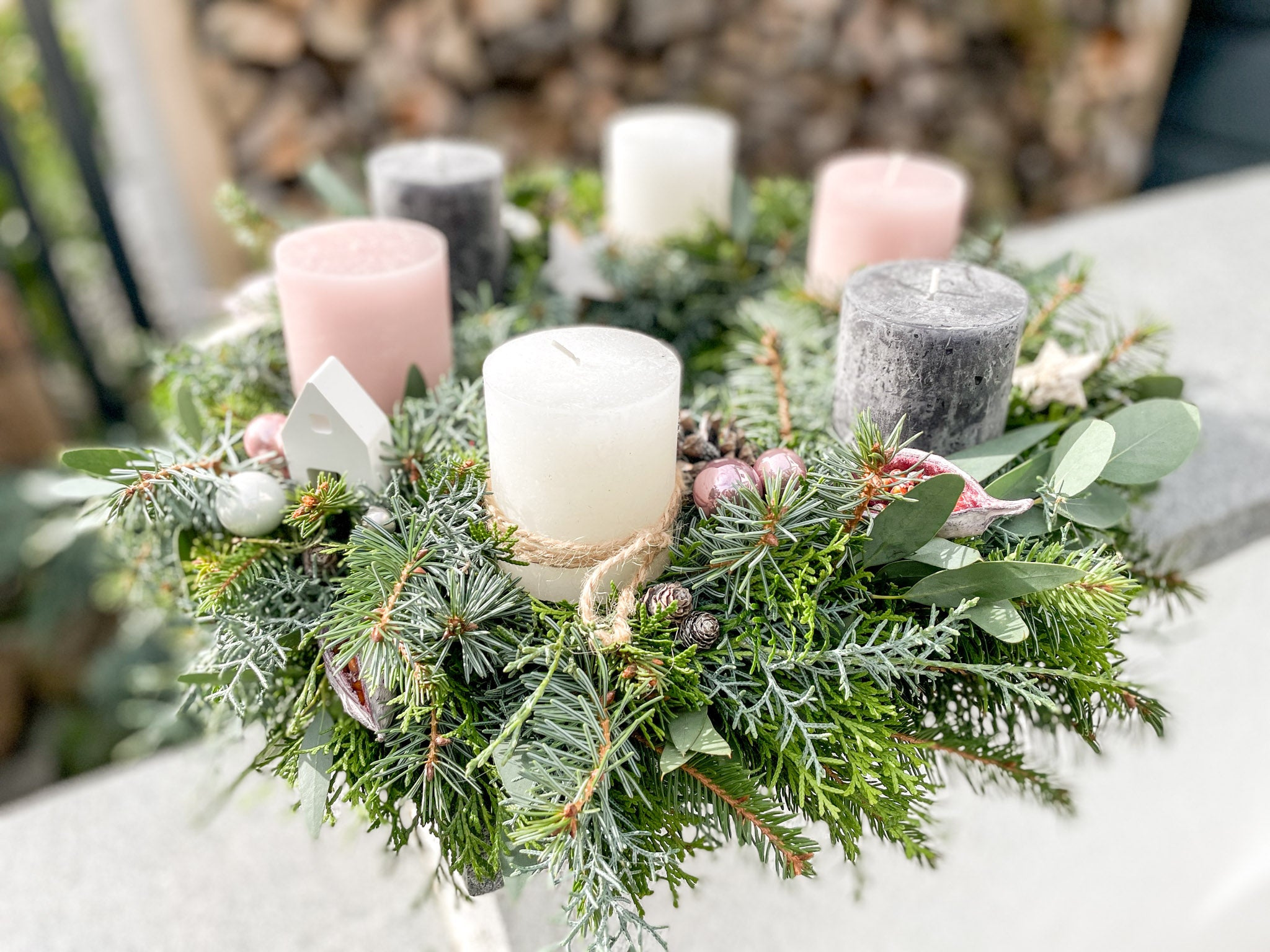 Nahaufnahme der Dekoelemente: Sterne aus Birkenrinde, farblich passende Kugeln und optional Sukkulente im Adventskranz »Lumière Aramée«.