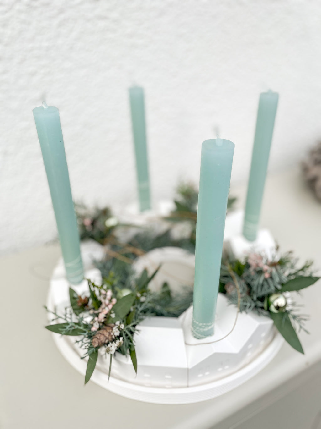 Vier Mint-Stabkerzen auf handgemachtem Adventskranz mit Tannengrün und Schleierkraut in Rosé und Weiß