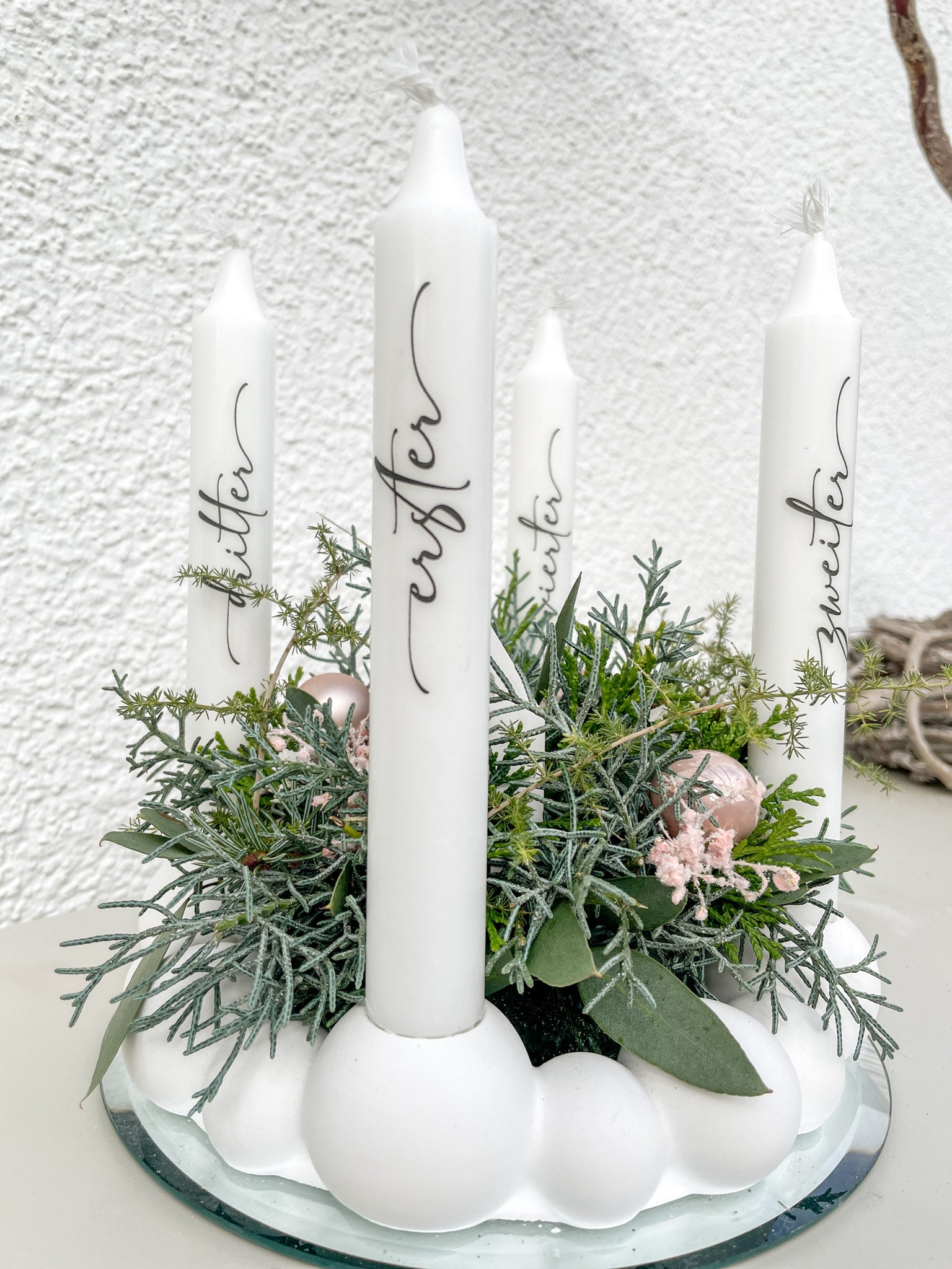 Moderner Adventskranz aus Raysin-Kugeln mit zentralem Nadelgrün-Bouquet, Stabkerzen und pastellfarbener Deko