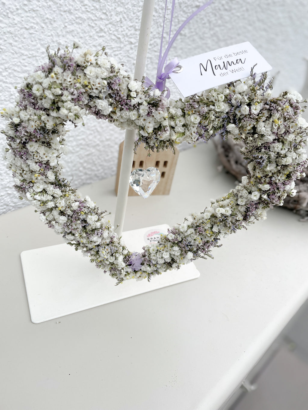 Weißes Blumen Herz aus Draht mit zarten Blüten und Kristall Sonnenfänger in der Mitte