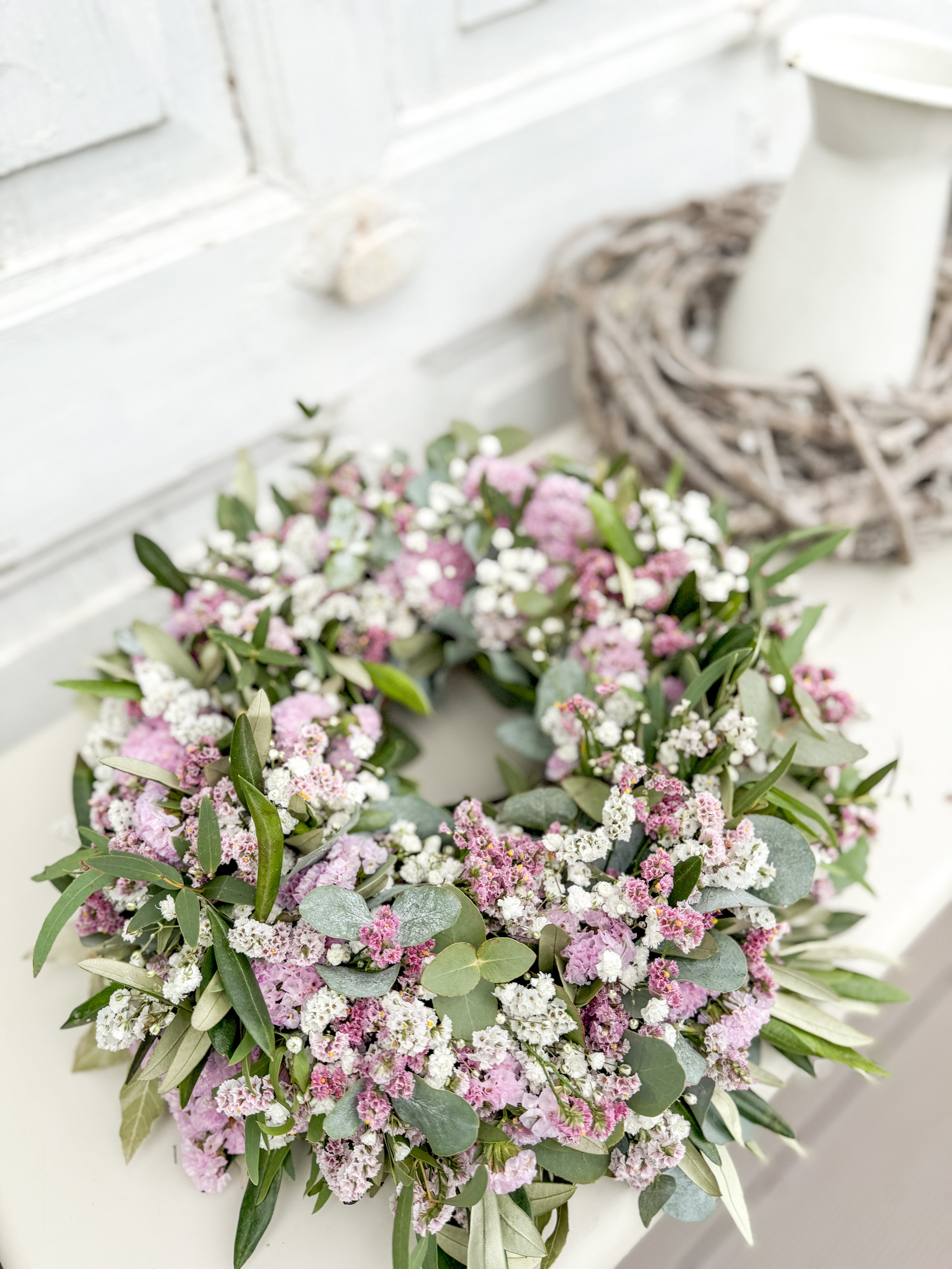 Frischer Kranz mit Blüten auf Tisch dekoriert - rosa