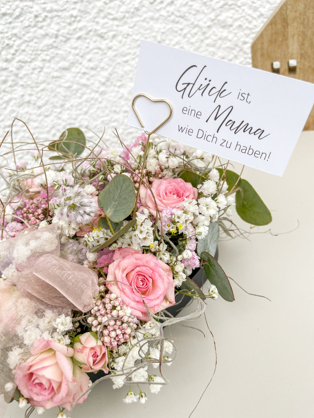 Frische rosa Rosen im Mittelpunkt eines handgefertigten Steckschaum-Herzens