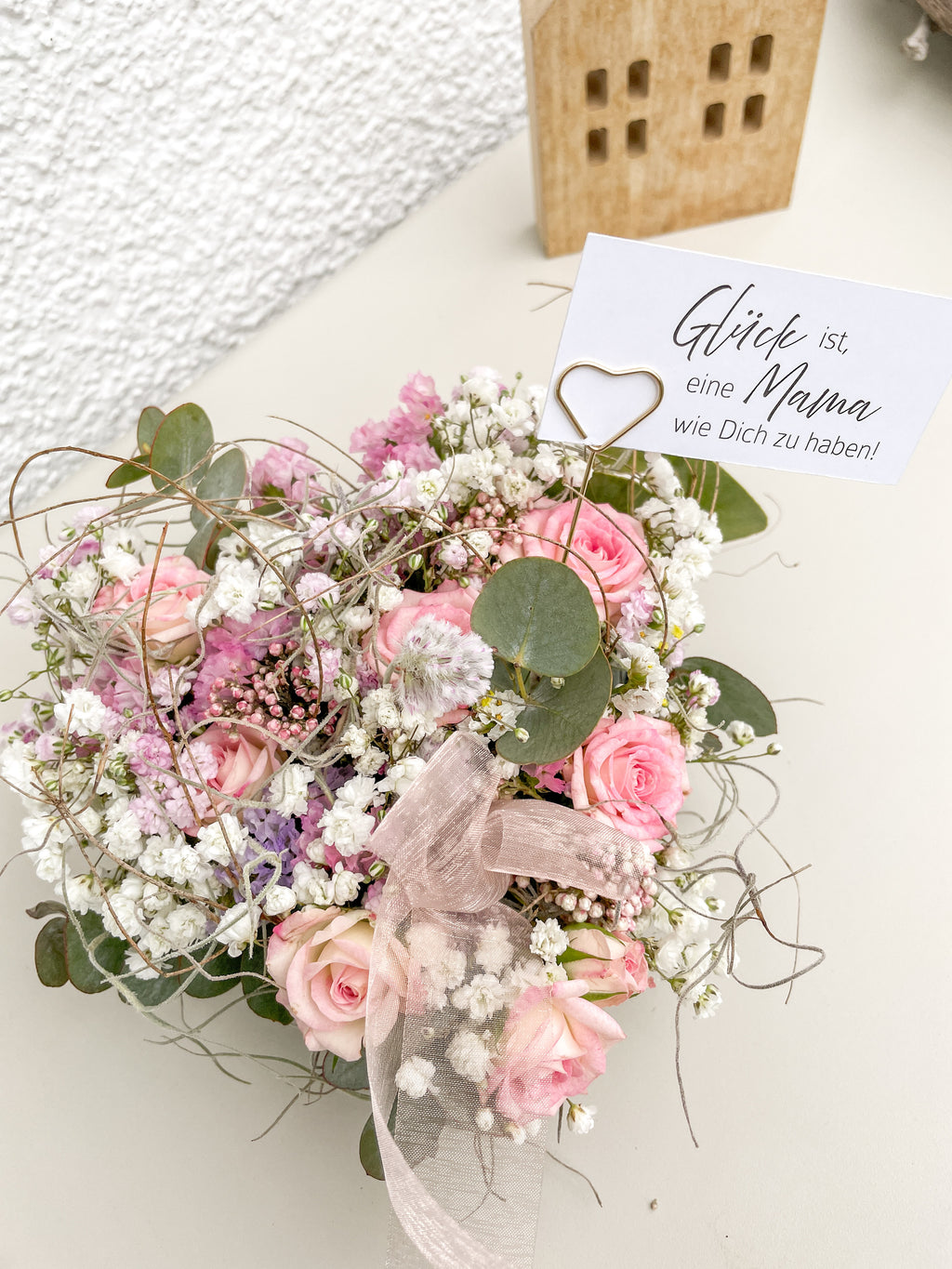 Florales Steckschaum-Herz mit rosa Rosen, Eukalyptus und Blüten in Herzform arrangiert