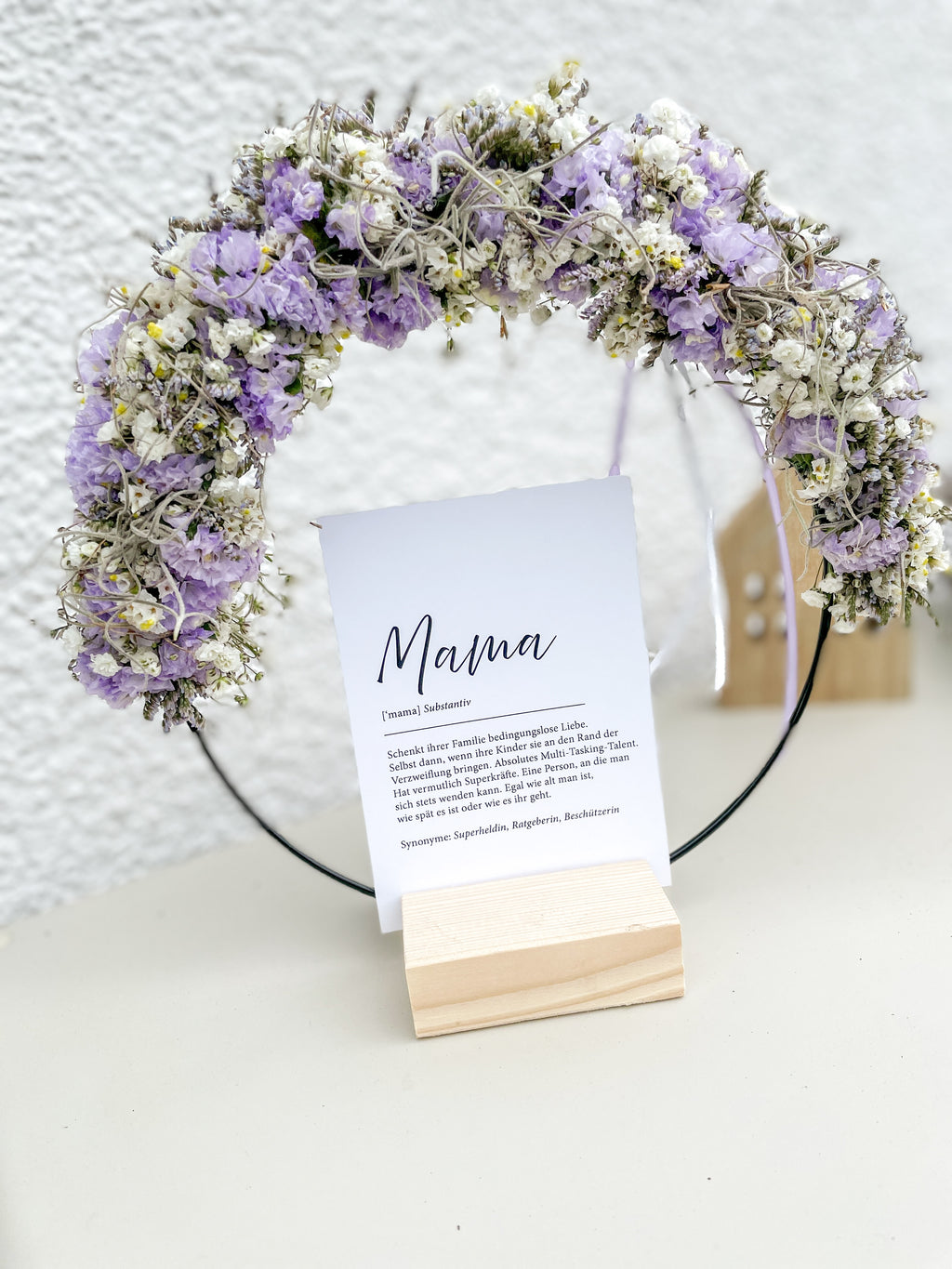 1/2 Flowerloop auf Holzständer mit frischen Blüten und Postkarte „Mama“ als Muttertagsdeko