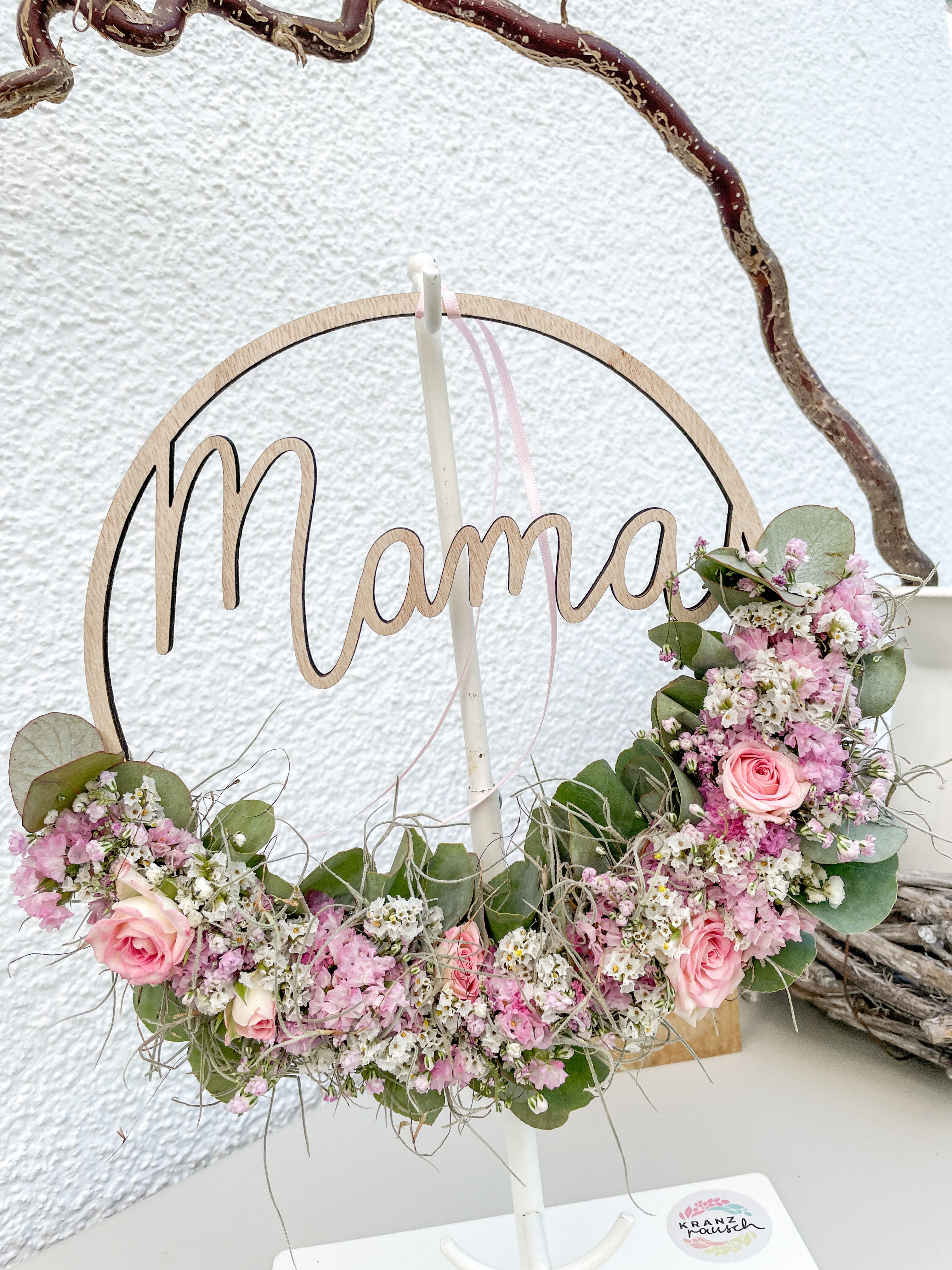 Handgemachter Holzloop mit halber floraler Dekoration aus frischem Eukalyptus und Blüten, ergänzt um kleine Rosen