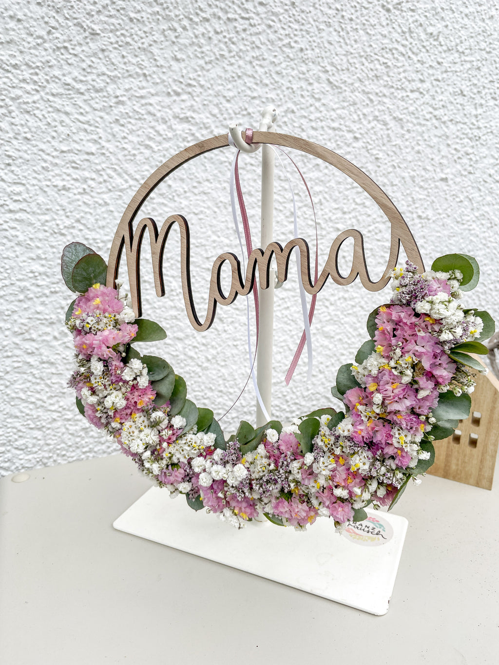 Dekorativer Holzloop „mama“ als Wand- oder Türschmuck mit natürlichen Blüten und Eukalyptus, rosa