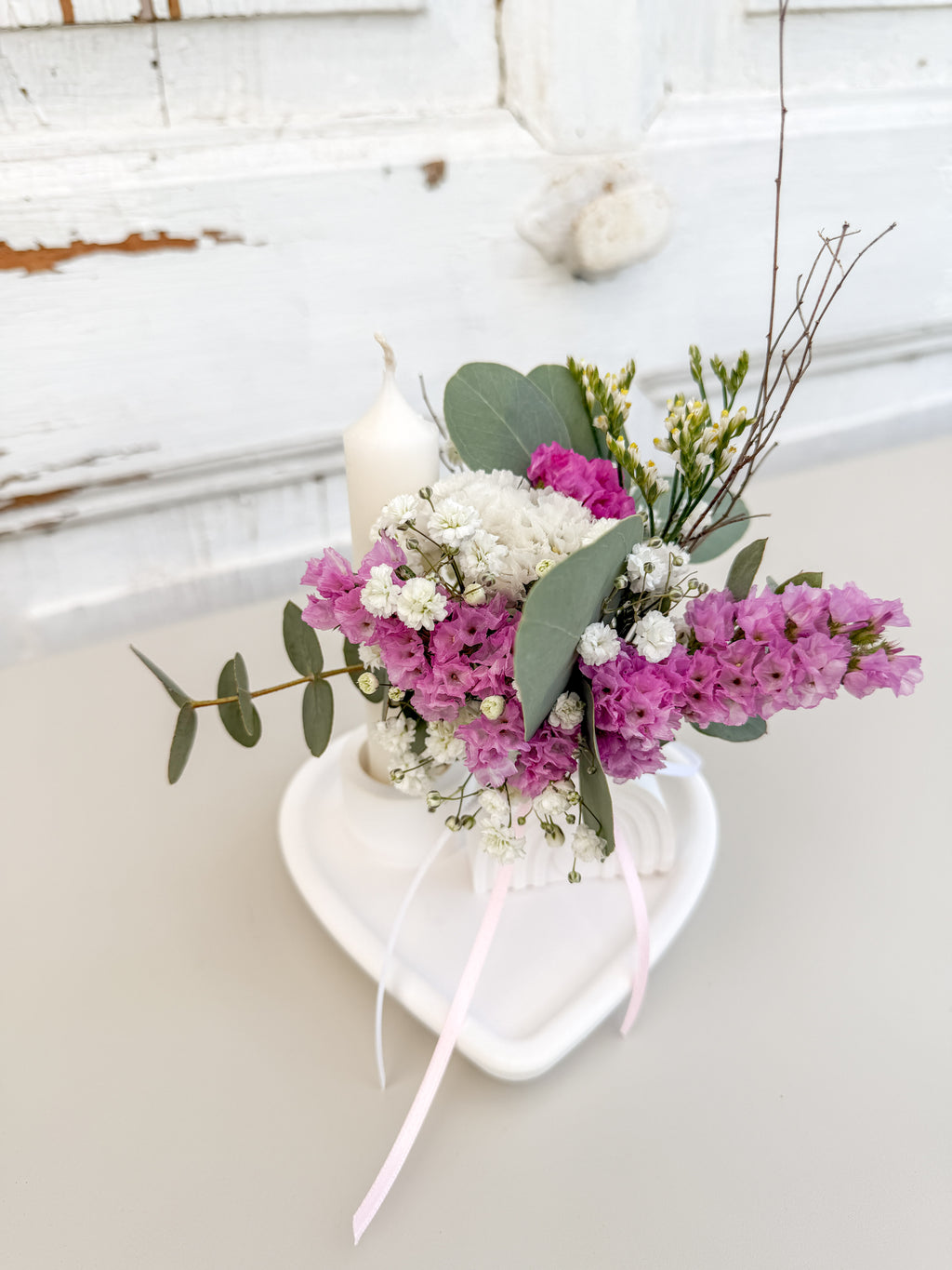 Raysinschale Herzform mit weißer Stabkerze und farblich abgestimmtem Blumenbouquet in rosa-eukalyptusfarben