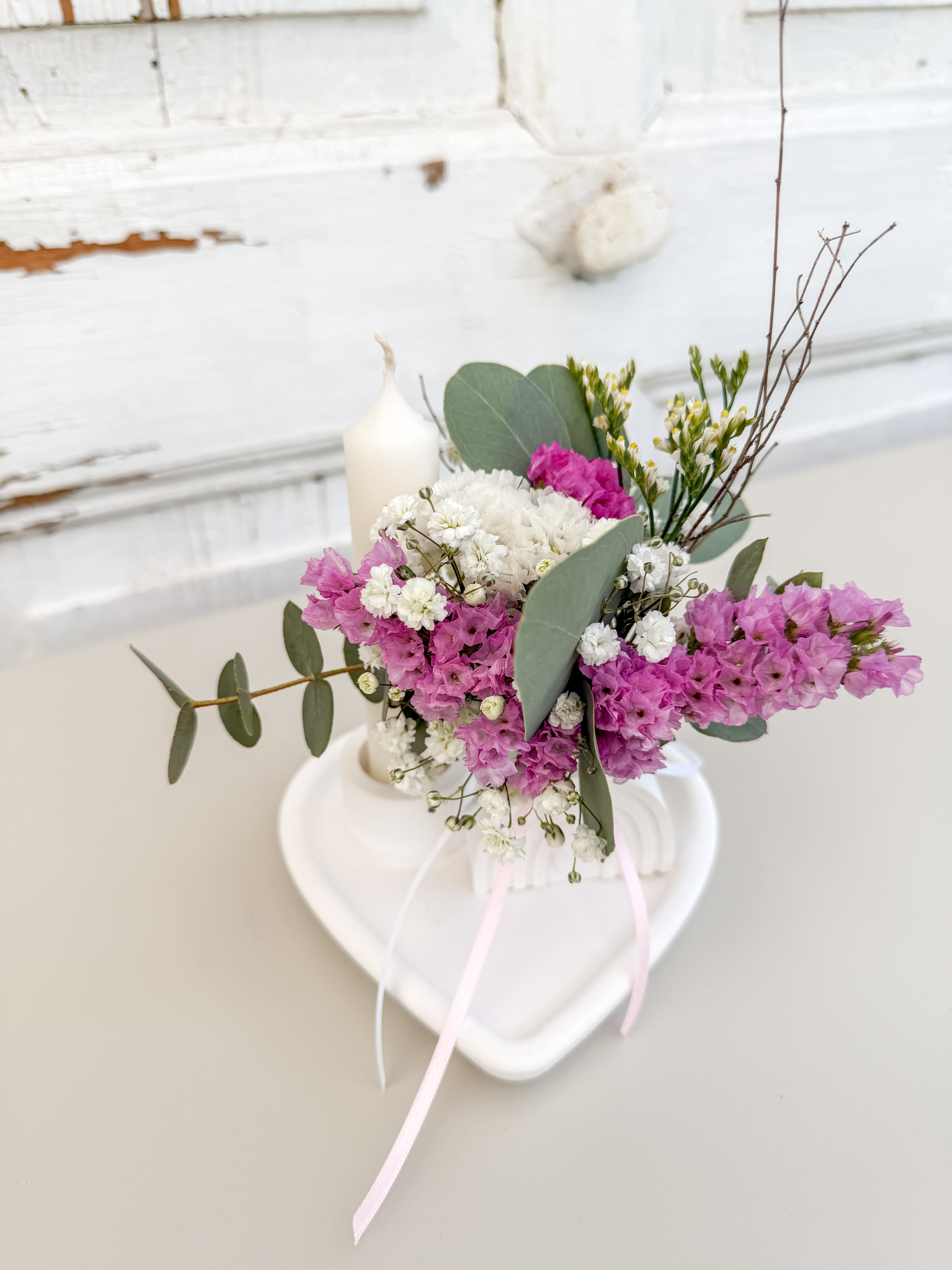 Raysinschale Herzform mit weißer Stabkerze und farblich abgestimmtem Blumenbouquet in rosa-eukalyptusfarben