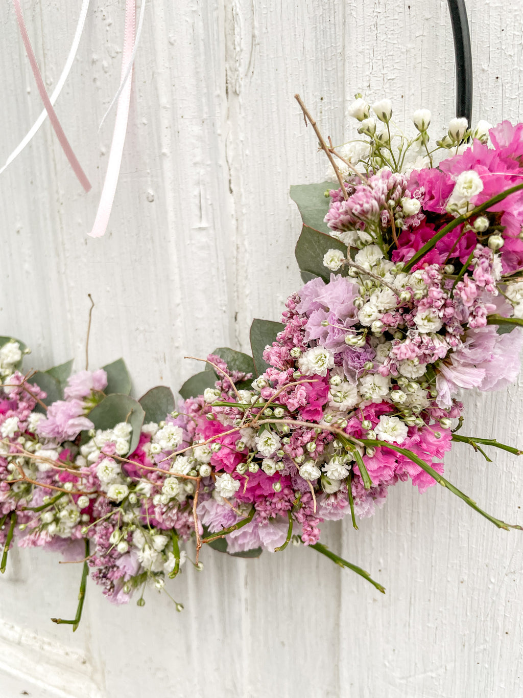 Detailaufnahme 1/2 Loop „Soft Seasons“ in Rosa: rosa Strandflieder, Statice, Limonium, Eukalyptus, Schleierkraut und Euphorbia spinosa auf Metallring, winterlich-frühlingshaft