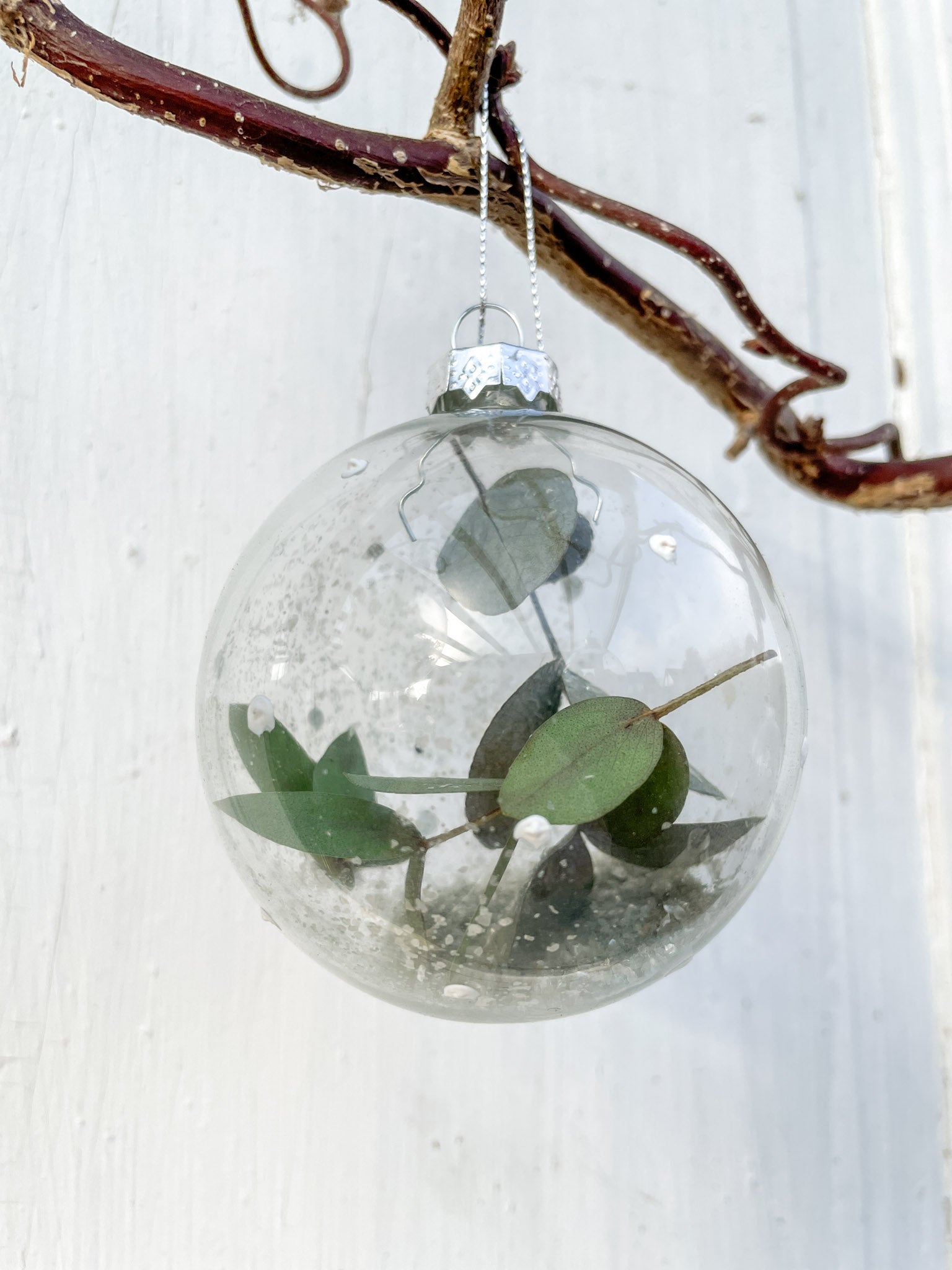 Glaskugel ‚Blütenzauber‘ Hochformat, transparent mit weißen Farbtupfen, gefüllt mit Eukalyptus und Glitterstaub