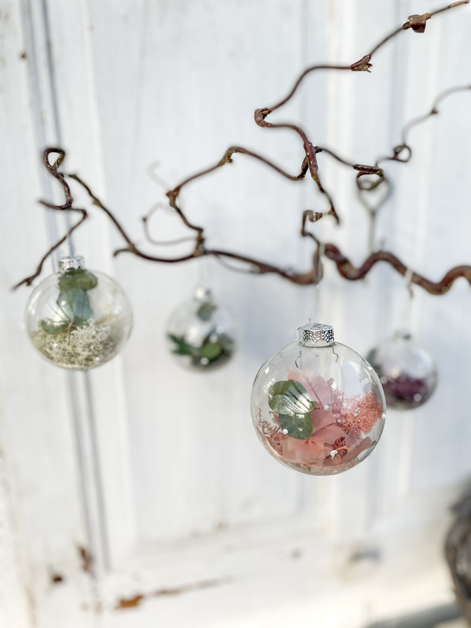 Glaskugel ‚Blütenzauber‘ Hochformat, transparent mit weißen Farbtupfen, gefüllt mit Islandmoos, Eukalyptus, Hortensien in Rosa/Lila und Glitterstaub