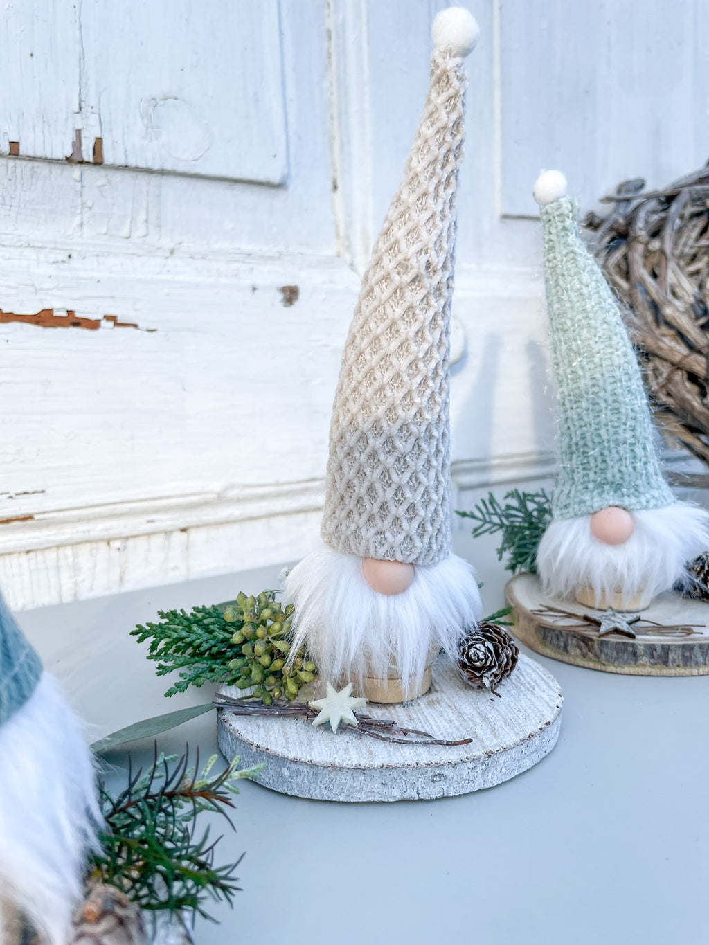 Kleiner Winterwichtel auf Holzscheibe, dekoriert mit Eukalyptus, Koniferengrün und Lerchenzapfen, handgemachte Winterdekoration aus Naturmaterialien