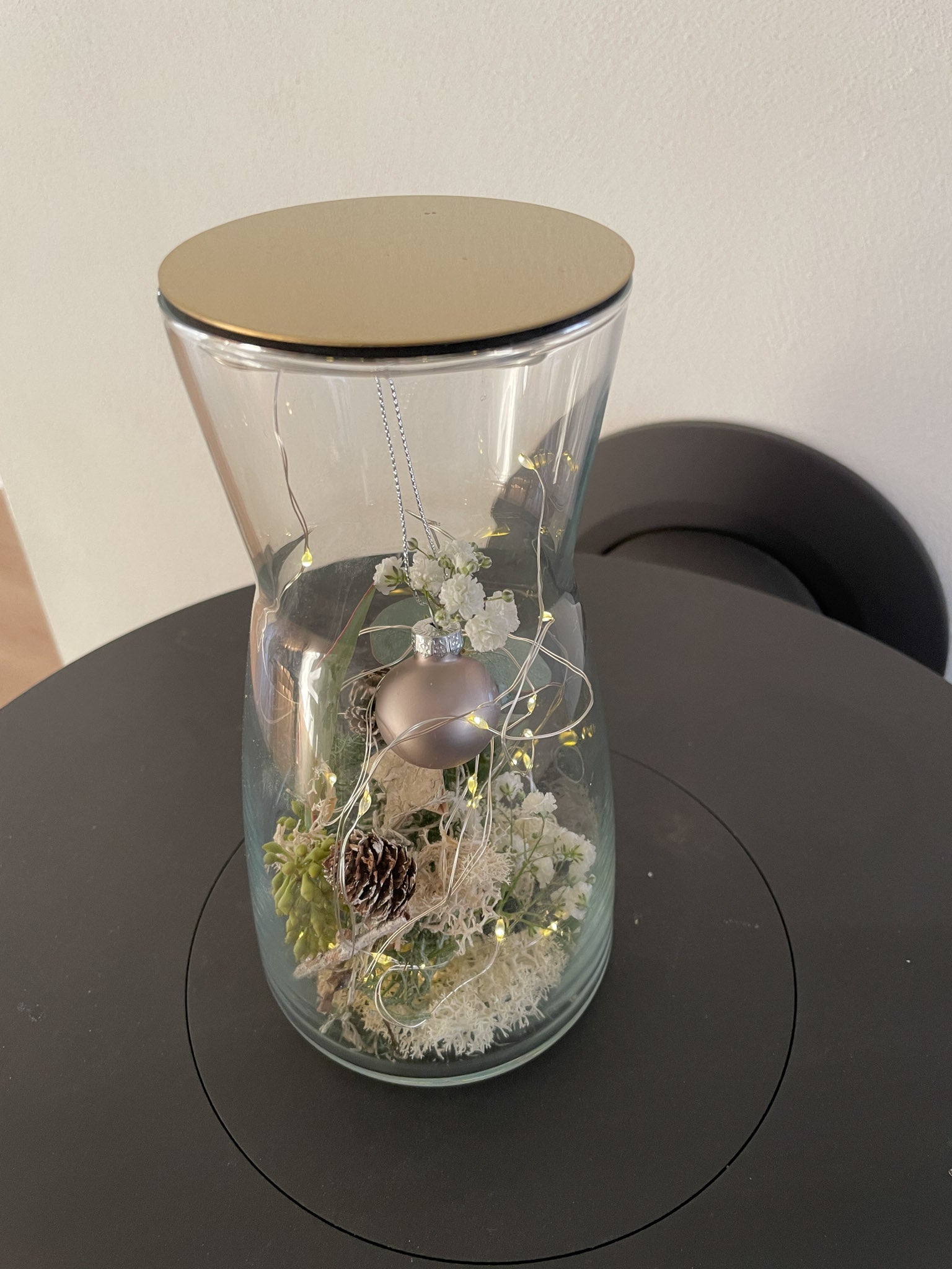 Glasvase Winterzauber mit goldfarbenem Deckel, Kugelanhänger Anthrazit, Nadelgrün, Eukalyptus, Zapfen, Islandmoss, dekoratives Winterarrangement