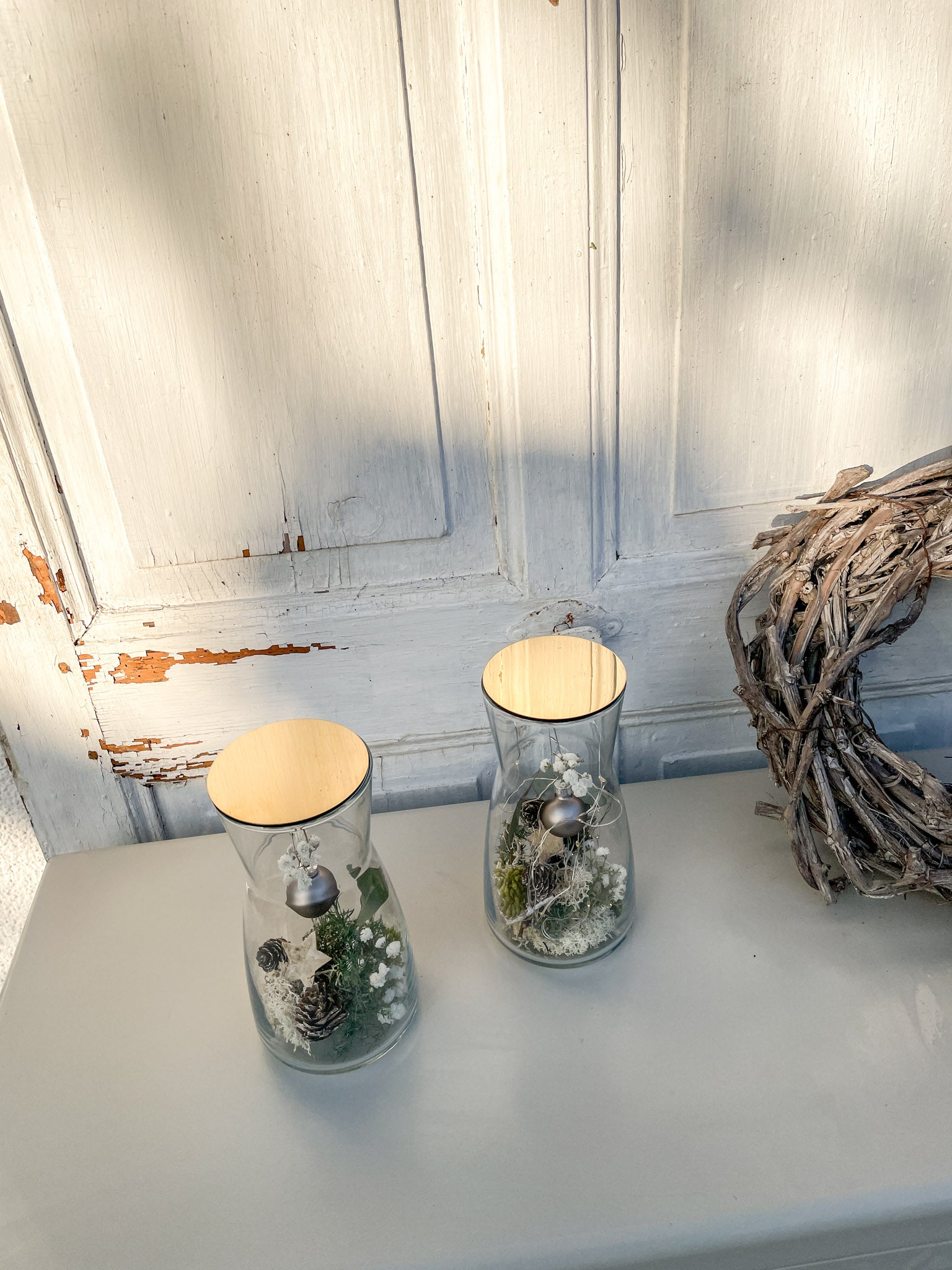 Glasvasen Winterzauber mit goldfarbenem Deckel, Kugelanhänger Anthrazit, Nadelgrün, Eukalyptus, Zapfen, Islandmoss, dekoratives Winterarrangement