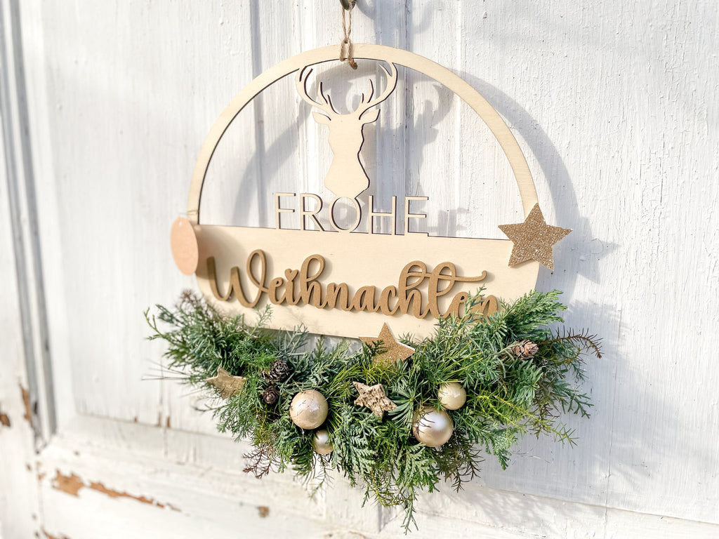 Holzloop ‚Frohe Weihnachten‘ Querformat, filigraner Schriftzug mit Koniferengrün in Blau- und Grüntönen, Kugeln in Gold- und Cremetönen, Birkensterne und Lerchenzapfen