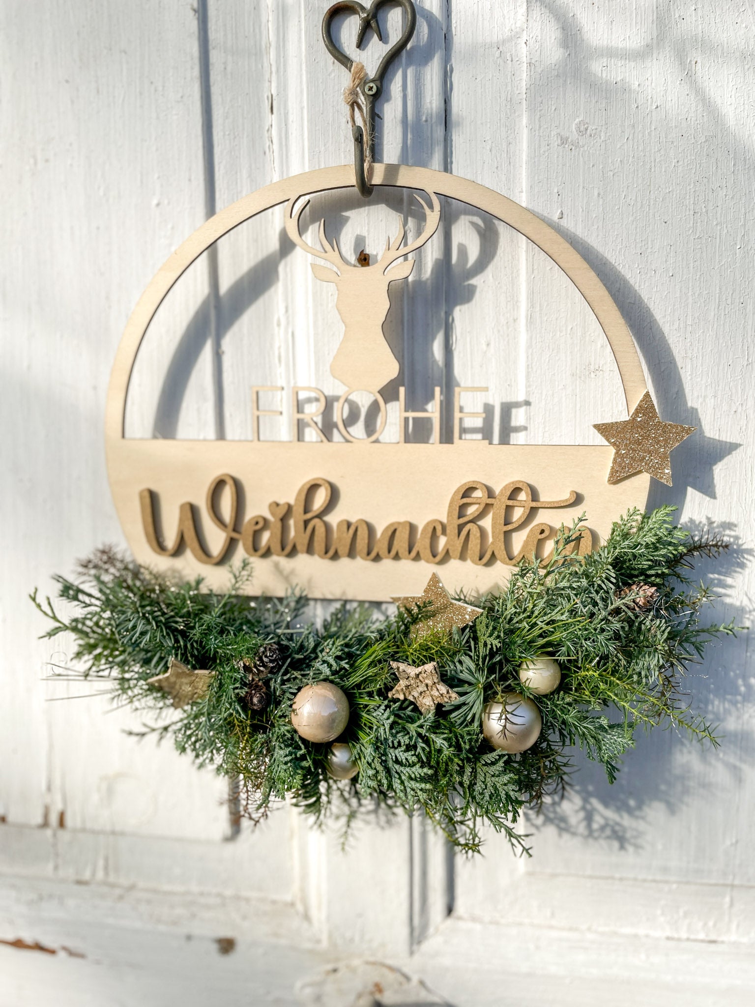 Holzloop ‚Frohe Weihnachten‘ Hochformat, filigraner Schriftzug mit Koniferengrün in Blau- und Grüntönen, Kugeln in Gold- und Cremetönen, Birkensterne und Lerchenzapfen