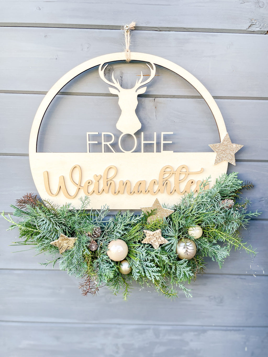Holzloop ‚Frohe Weihnachten‘ Hochformat, filigraner Schriftzug mit Koniferengrün in Blau- und Grüntönen, Kugeln in Gold- und Cremetönen, Birkensterne und Lerchenzapfen