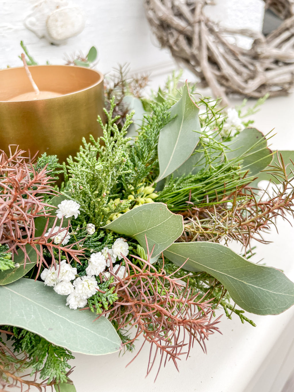 Nahaufnahme des Winterkranzes ‚Cozy Forest‘ mit Eukalyptus und weißem Schleierkraut, zarte winterliche Akzente auf Koniferengrün