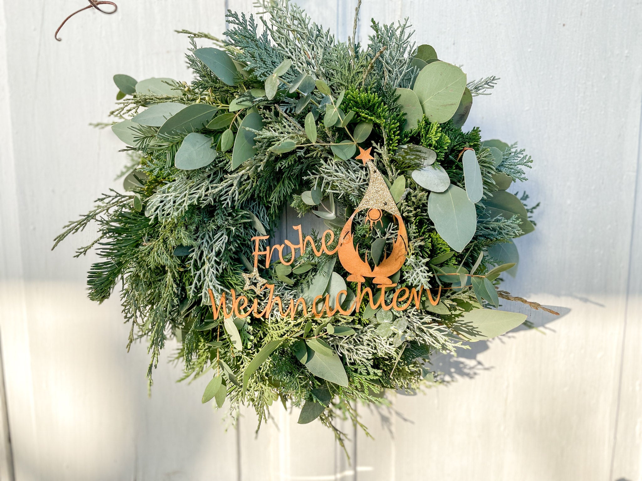 Winterkranz Frohe Weihnachten, handgefertigt, Kranzbasis aus Eukalyptus & Koniferengrün, Schriftzug Metall rostfarben, Winterwichtel und Goldakzente
