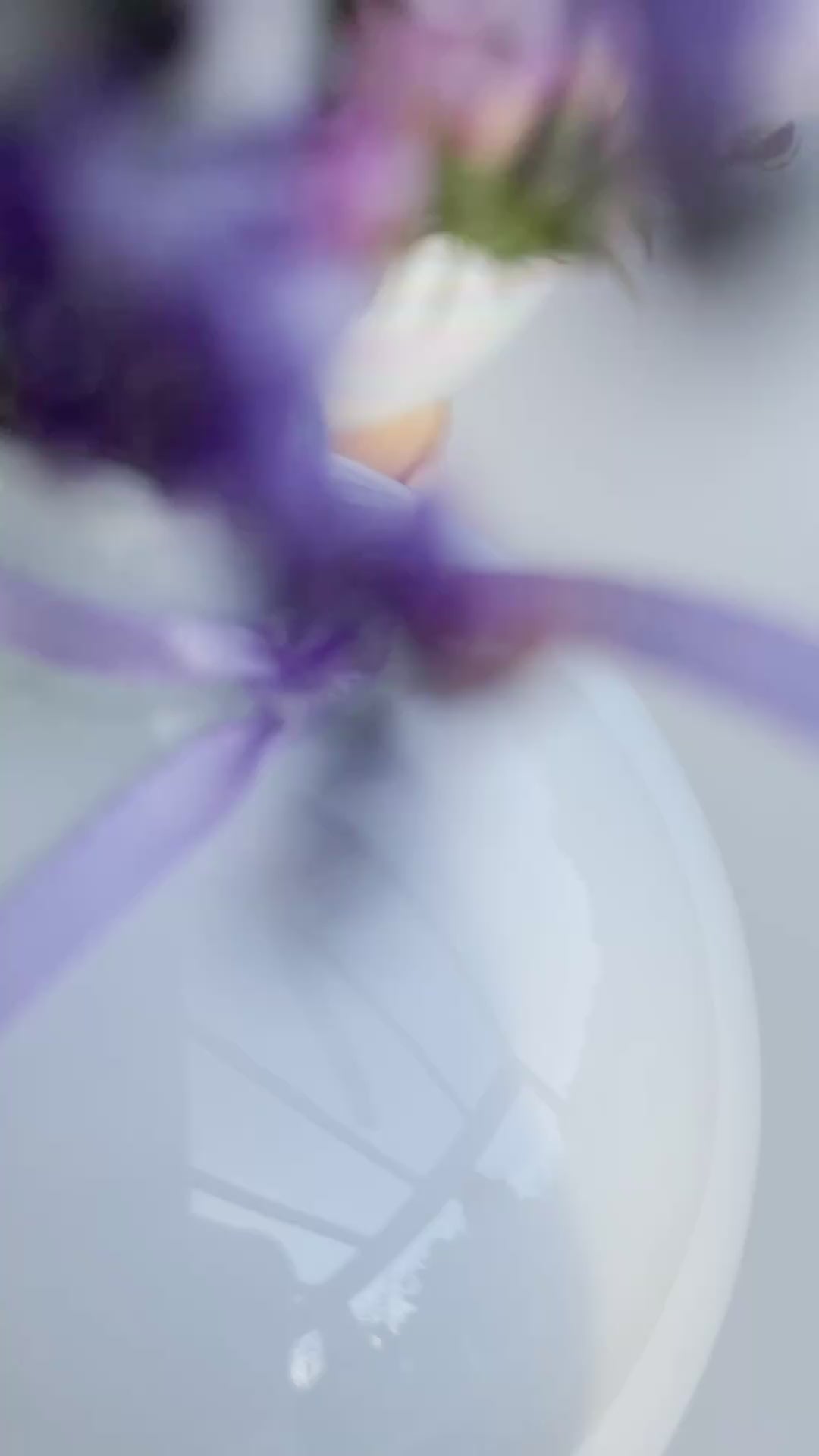 Video zeigt die Christbaumkugel-Vase ‚Lila Blütenzauber‘: Glasvase mit Perlmutschimmer auf Holzscheibe, gefüllt mit Mini-Bouquet aus Eukalyptus, Strandflieder, Limonium, Statice in Lila und weißem Schleierkraut. Perspektiven inklusive Hochformat