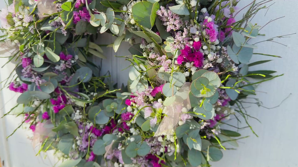 Video eines handgefertigten Frühlingskranzes aus Eukalyptus und Blüten im Querformat