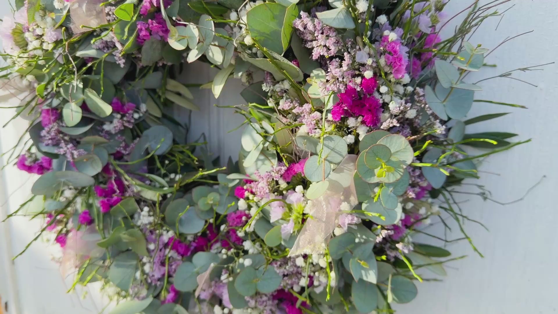 Video eines handgefertigten Frühlingskranzes aus Eukalyptus und Blüten im Querformat